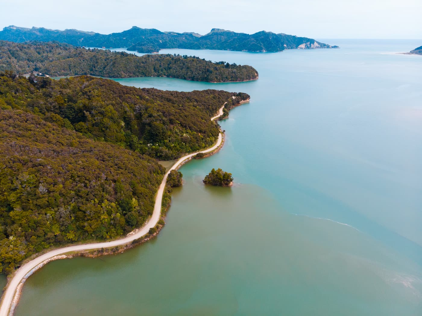 Winding road over Takaka Hill with wide views over valleys and bays in Golden Bay, New Zealand