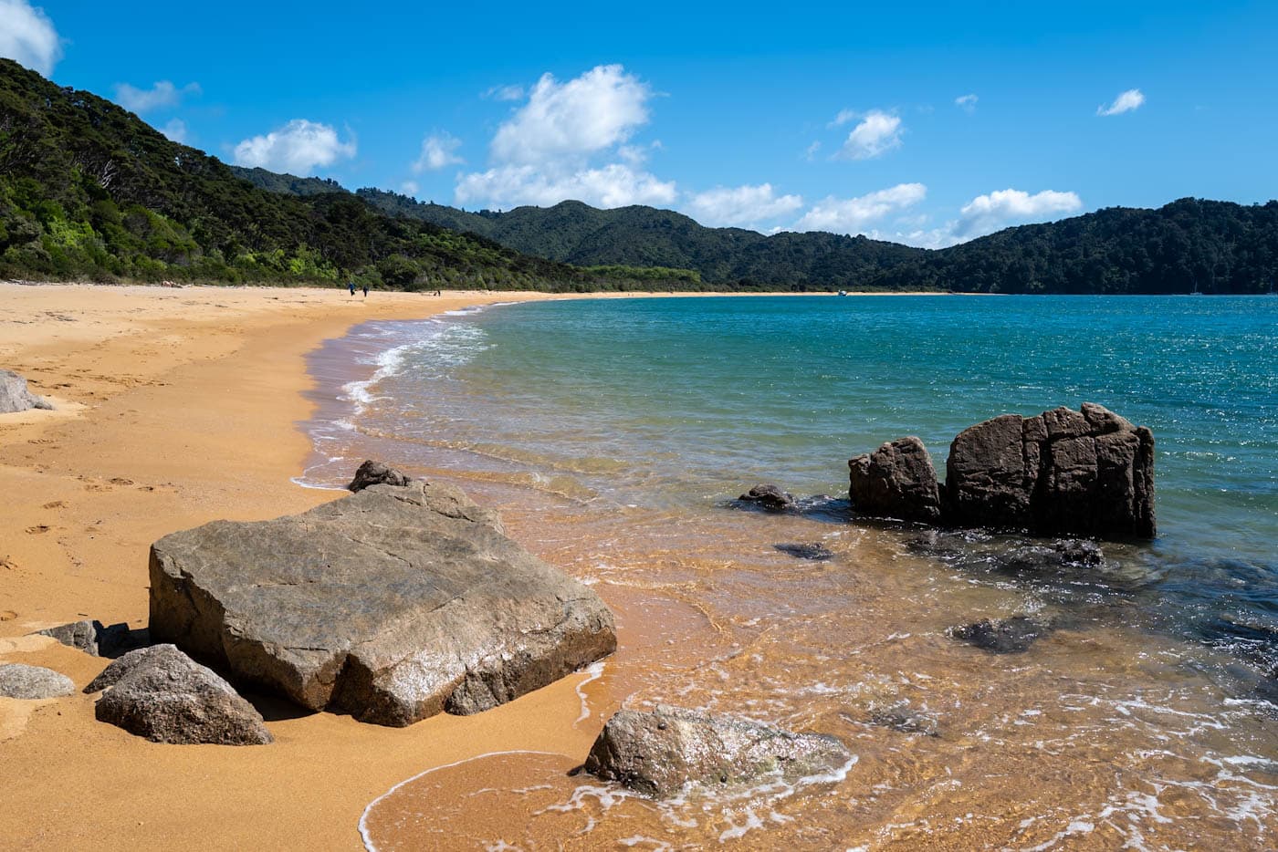 Wide sandy bay with calm, shallow water and gentle waves in Golden Bay, New Zealand